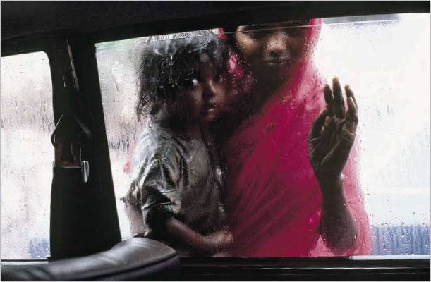 L'INDE. Bombay. 1993. Une mère et son enfant mendient à travers la fenêtre d'un taxi pendant la mousson