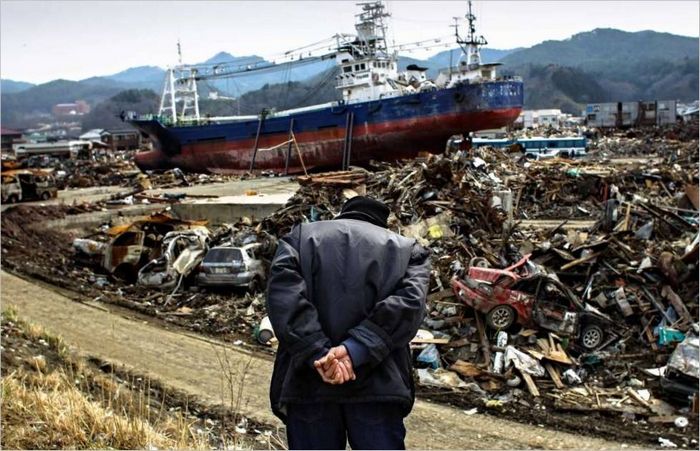 Un vieil homme japonais regarde en bas d'une colline la ville d'Ishinomaki, ravagée par le tsunami. 2011 g